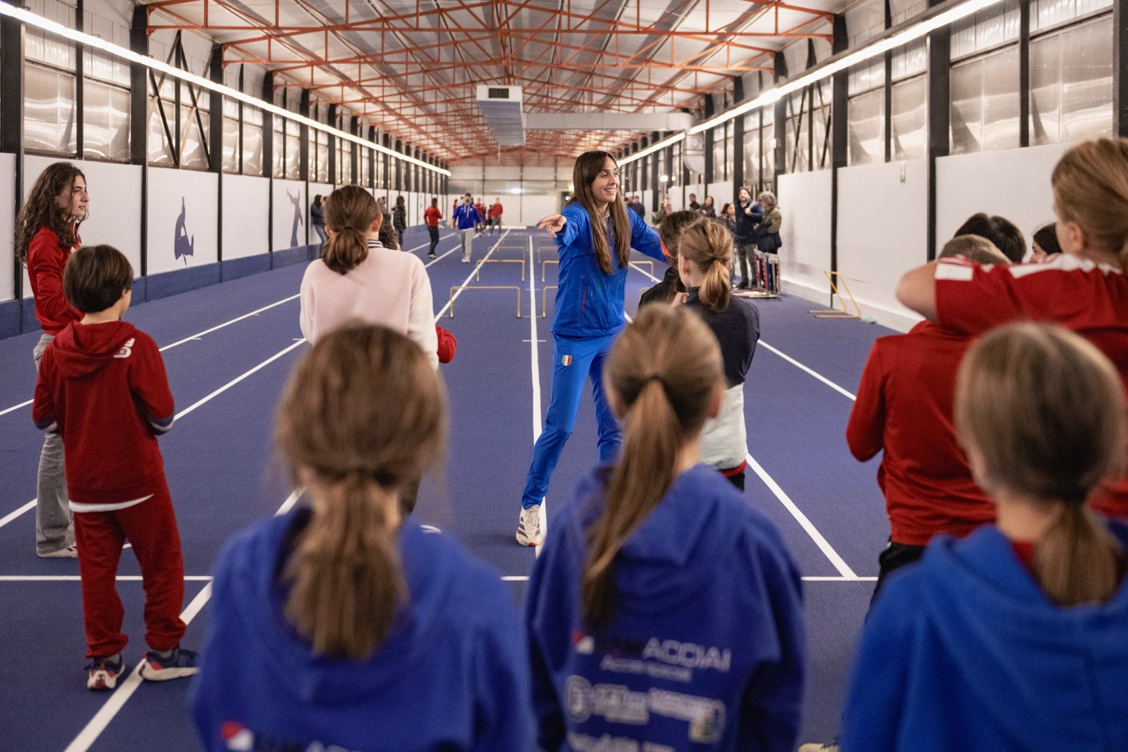 Ragazzi sulla pista indoor blu della Sisport