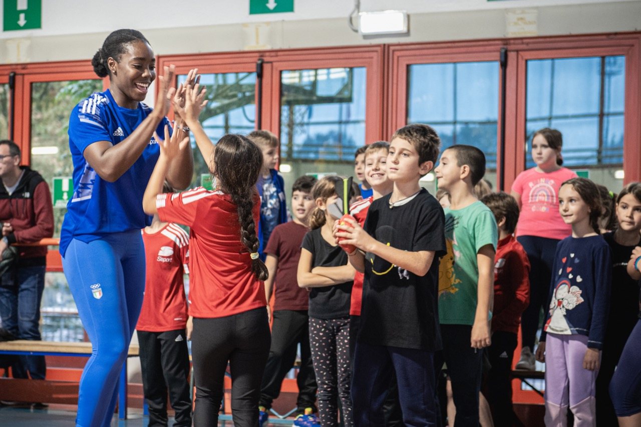 Un'atleta azzurra batte il cinque a una ragazza
